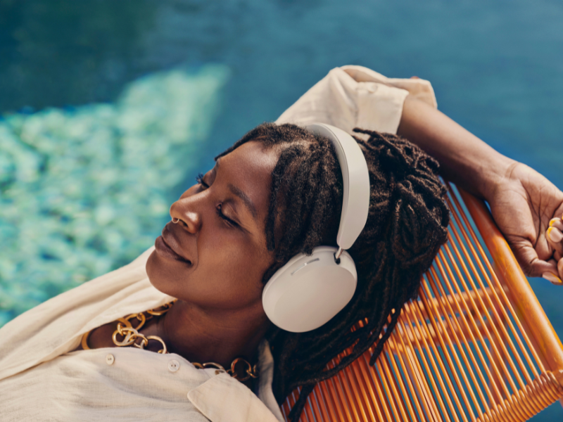 Sonos Kopfhörer Ace-Reihe bei einer Frau, die am Pool entspannt